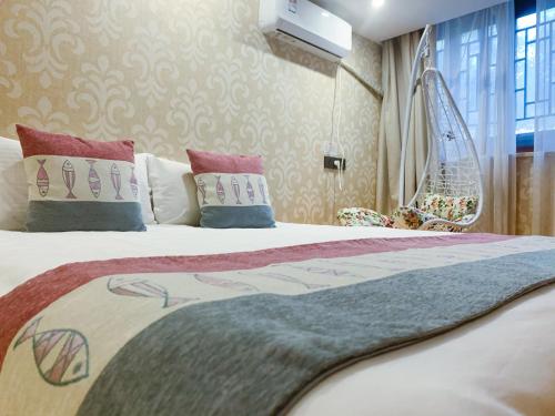 a bedroom with a large bed with pillows at Suzhou Jade Snow Lodge in Suzhou