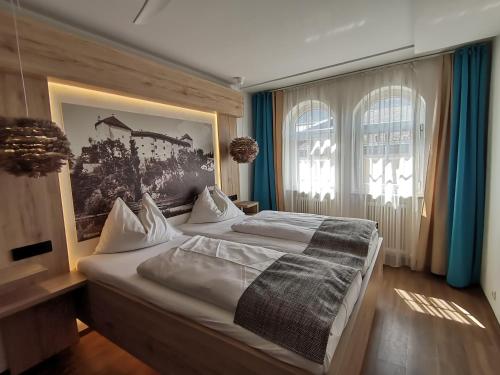 ein Schlafzimmer mit einem großen Bett mit einem Bild an der Wand in der Unterkunft Hotel Adler in Golling an der Salzach