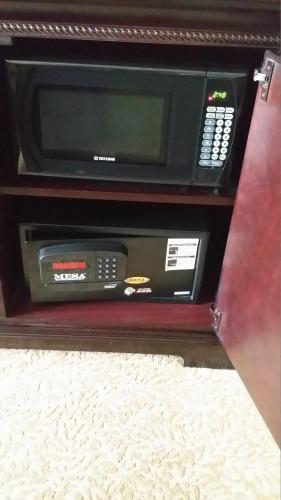 a microwave in a wooden drawer with a phone in it at Country Inn & Suites by Radisson, Minot, ND in Minot