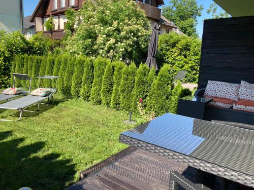 a garden with a bench and a table and a hedge at Kal's Studio Apartment Salzburg in Salzburg