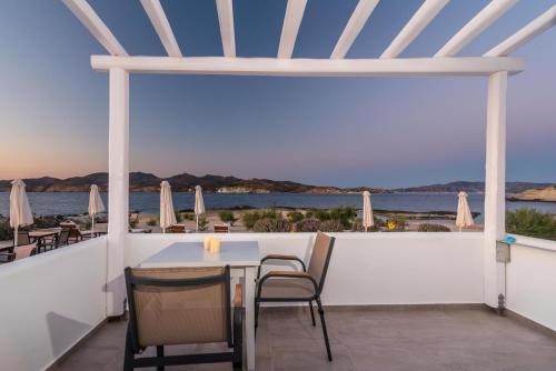 a table and chairs on a balcony with a view of the ocean at Tania Milos in Pollonia