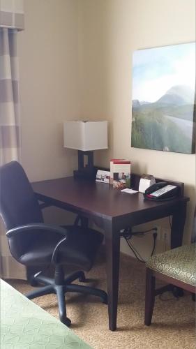 a desk with a chair and a lamp in a room at Country Inn & Suites by Radisson, Minot, ND in Minot