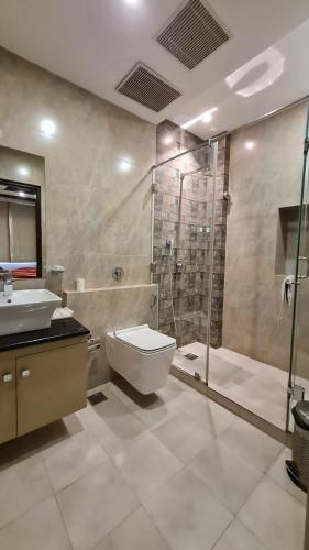y baño con ducha, aseo y lavamanos. en Hotel Diplomat Residency, en Nueva Delhi