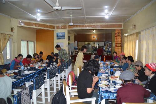 a group of people sitting at tables eating food at Madina Hotel 2 in Gilgit