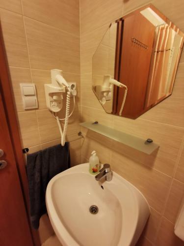 a bathroom with a sink and a mirror at Promenade Apartman in Siófok