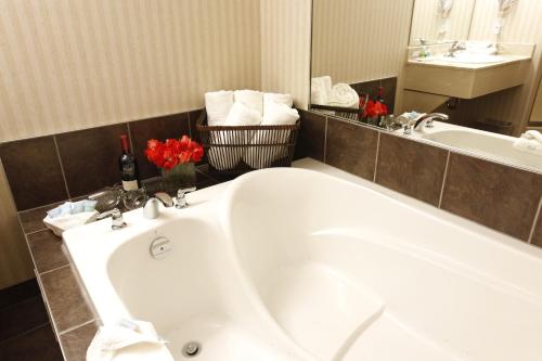 a bathroom with a white tub and a sink at Pomeroy Inn and Suites Dawson Creek in Dawson Creek