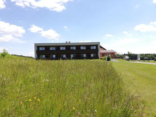 a building on a hill with a field of grass at Golf Resort Klöch in Klöch