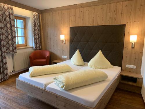 1 dormitorio con 1 cama grande y 1 silla en Gästehaus am Graben, en Reutte