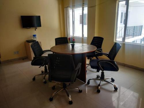 a meeting room with a wooden table and chairs at Abuzz Oxfordcaps Simla in Shimla