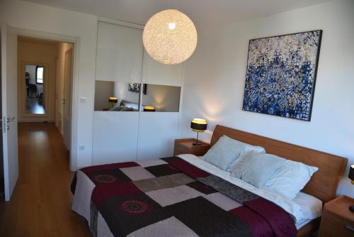 een slaapkamer met een bed en een schilderij aan de muur bij 4-star Zagreb Penthouse in Zagreb