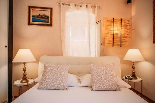 a bedroom with a bed with two lamps and a window at Private Villa at Villa al Duomo in Taormina