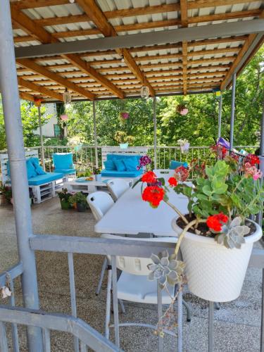 a patio with a table and chairs and flowers at Tskaltubo Terrace in Tskaltubo