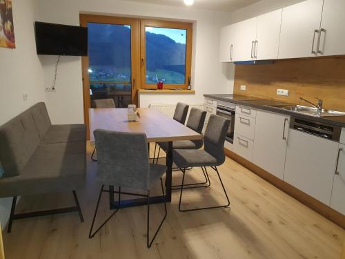 a kitchen with a table and chairs in a room at Gästehaus Flörl 1 in Gerlosberg