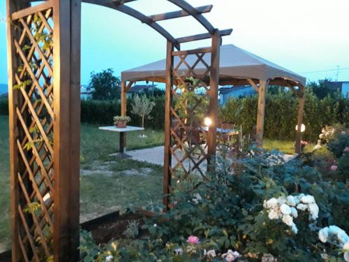 a wooden gazebo in a garden with flowers at Villa Monica in Pistoia