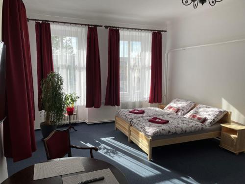 Schlafzimmer mit einem Bett und roten Vorhängen in der Unterkunft Apartmán Netolice 207 Deluxe in Netolice