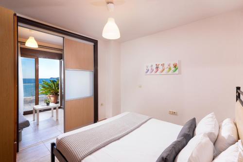 a bedroom with a bed and a sliding glass door at Golden Breeze in Chrysi Ammoudia