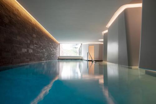 a swimming pool in a room with a brick wall at Hotel Les Haras in Strasbourg