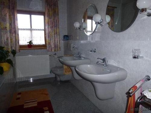 ein Badezimmer mit zwei Waschbecken, einem WC und einem Spiegel in der Unterkunft Ferienwohnung Fernblick in Freyung