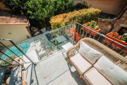 a balcony with two chairs and a table and flowers at Private Villa at Villa al Duomo in Taormina