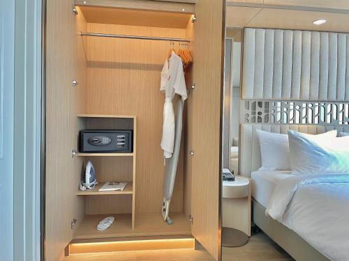 a small bedroom with a bed and a closet at Swiss-Belhotel Solo in Solo