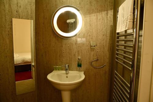 y baño con lavabo y espejo. en The Knighton Hotel, en Knighton