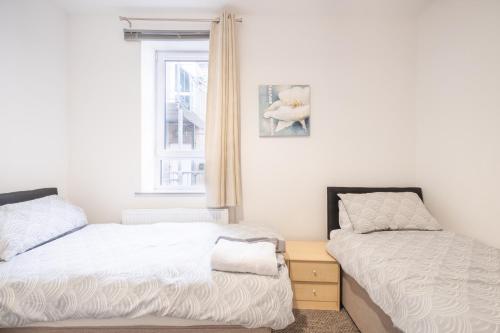a bedroom with two beds next to a window at Portrush Marine Apartments flat 3 in Portrush