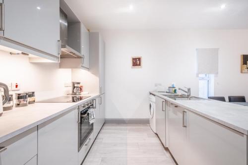 a kitchen with white counters and stainless steel appliances at Portrush Marine Apartments flat 3 in Portrush