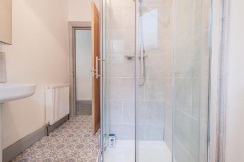 a shower with a glass door in a bathroom at Portrush Marine Apartments flat 3 in Portrush