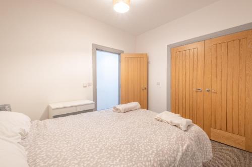 a bedroom with a bed with two towels on it at Portrush Marine Apartments flat 3 in Portrush