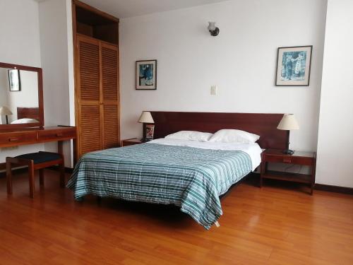a bedroom with a bed and a wooden floor at Room in Guest room - Comfotable Room in excelent location in Bogotá