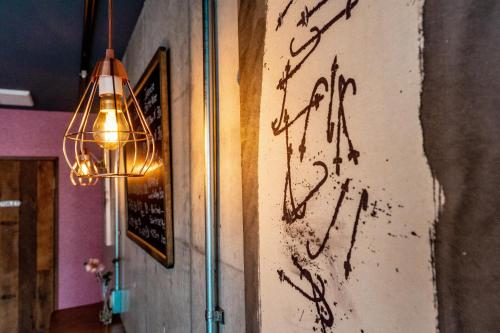 a wall with writing on it next to a lamp at MATERIAL Fuchomae in Kyoto