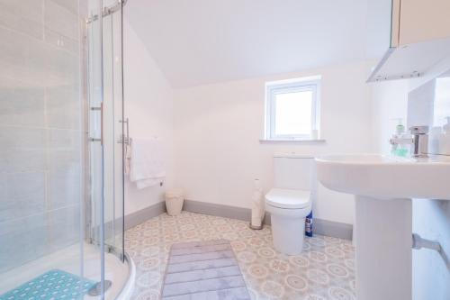 a bathroom with a shower and a sink and a toilet at Portrush Marine Apartments flat 3 in Portrush