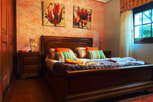 Un dormitorio con una cama con almohadas de colores y una ventana en A Chabola Mondariz, en Pontevedra