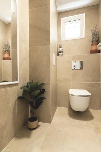 a bathroom with a toilet and a potted plant at La Finca - Saint Vlas in Sveti Vlas