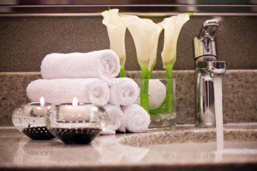 a bathroom sink with towels and candles on a counter at Mövenpick Hotel Izmir in Izmir