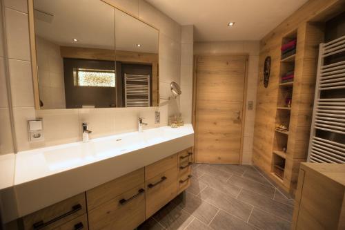een badkamer met een wastafel en een grote spiegel bij Huber Apartments in Kappl