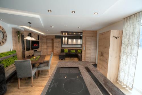 a kitchen and dining room with a table and chairs at Huber Apartments in Kappl