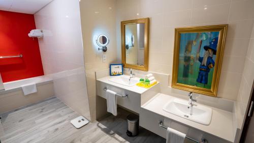 a bathroom with two sinks and two mirrors at LEGOLAND Hotel Dubai in Dubai