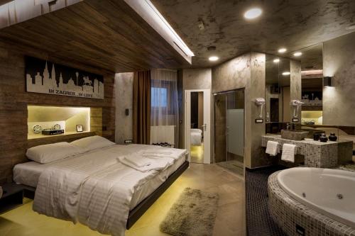 een slaapkamer met een groot bed en een bad bij Bedroom more than a bed in Zagreb