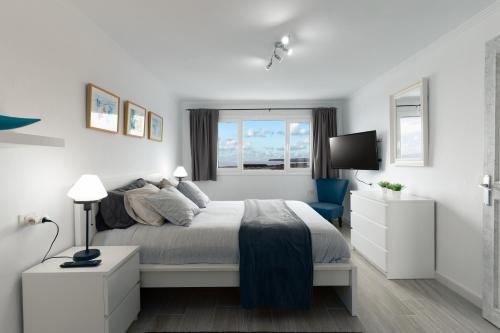 une chambre blanche avec un lit et une fenêtre dans l'établissement Casa Salinas del Mar, à Guatiza
