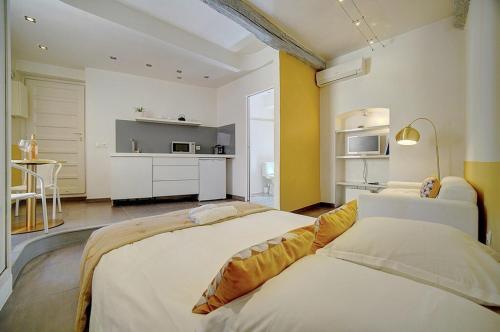 une chambre avec deux lits et une cuisine à l'intérieur dans l'établissement STUDIO MODERNE CENTRE HISTORIQUE DE CANNES VIEUX PORT-BAS SUQUET l- A0B65, à Cannes