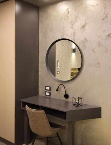 a mirror on a wall with a desk and a chair at Bedroom more than a bed in Zagreb
