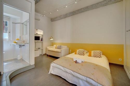 une chambre avec un lit et une chaise dedans dans l'établissement STUDIO MODERNE CENTRE HISTORIQUE DE CANNES VIEUX PORT-BAS SUQUET l- A0B65, à Cannes