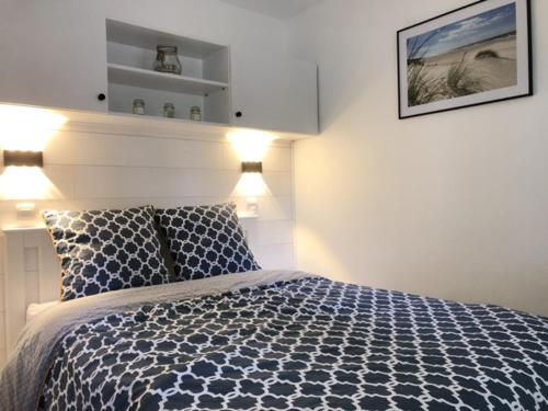 une chambre avec un lit bleu et blanc avec des lumières dans l'établissement Ravissant Appartement au Domaine du Golf, à Lacanau