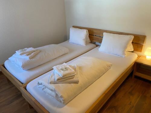 two beds in a room with towels on them at Berggasthaus Piz Calmot in Andermatt