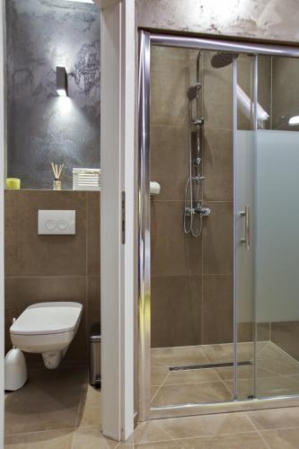 a bathroom with a toilet and a glass shower at Bedroom more than a bed in Zagreb