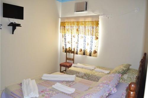 a room with two beds and a window at Pousada Miosotis in Nova Viçosa