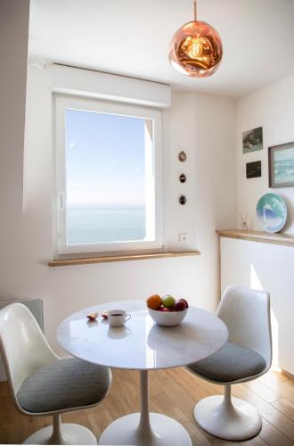 a white table and chairs in a room with a window at Villa le Courlis Panoramic see view in Ault