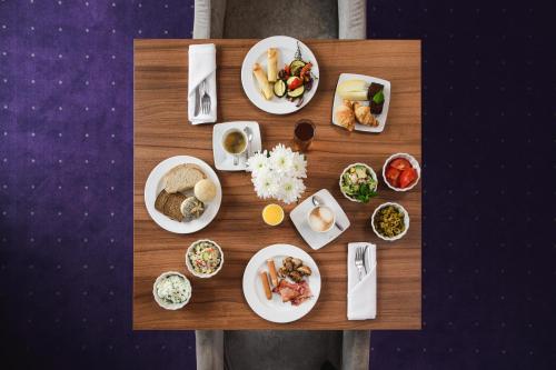 einen Tisch mit Teller mit Lebensmitteln drauf in der Unterkunft Best Western Plus Hotel Olsztyn Old Town in Olsztyn