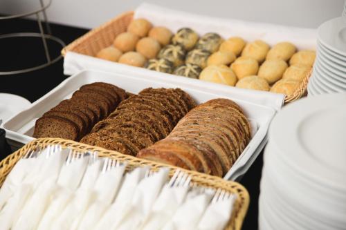 a tray of different types of bread and pastries at Best Western Plus Hotel Olsztyn Old Town in Olsztyn